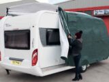 Two people fitting a caravan cover