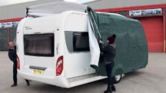 Two people fitting a caravan cover