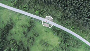 An aerial tracking shot of a car and caravan on the road