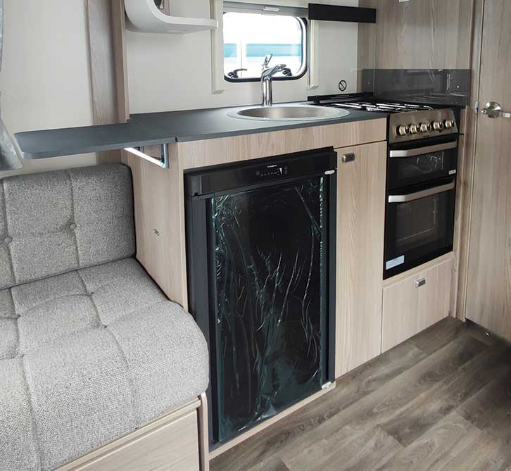 The kitchen of the Swift Sprite Major with a large fridge, oven and hob and fold-out work top.