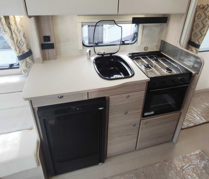 Kitchenette of the Xplore caravan, including a sink, hob and cupboards.