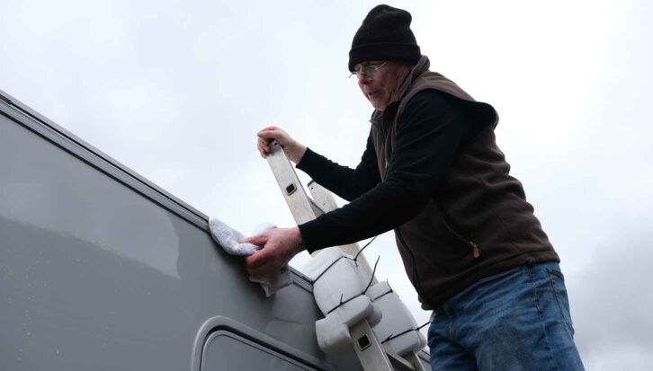 Cleaning the awning rail with a cloth