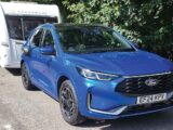 The Ford Kuga 2.5 FHEV 183PS ST-Line X AWD hitched up to a caravan