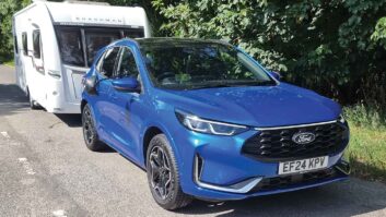 The Ford Kuga 2.5 FHEV 183PS ST-Line X AWD hitched up to a caravan