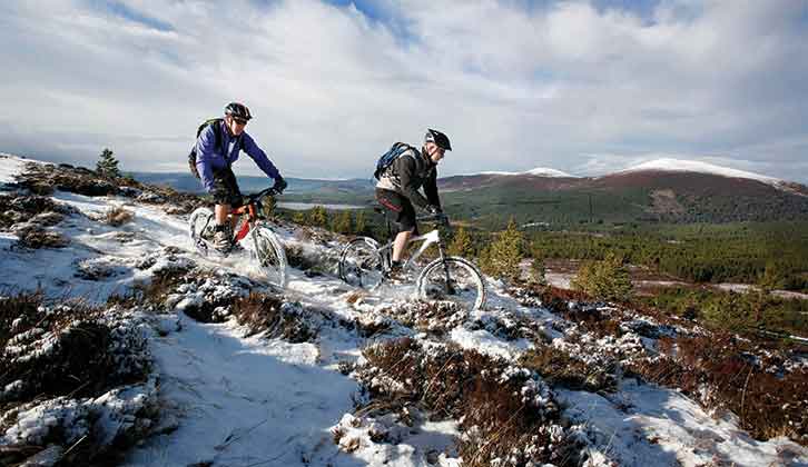 A couple cycling in Scotland in wintery conditions