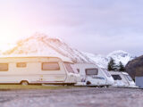 Caravans pitched up in front of snow-topped mountains