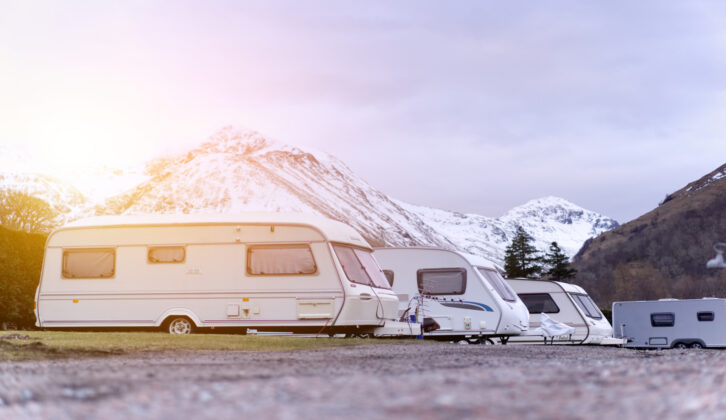 Caravans pitched up in front of snow-topped mountains